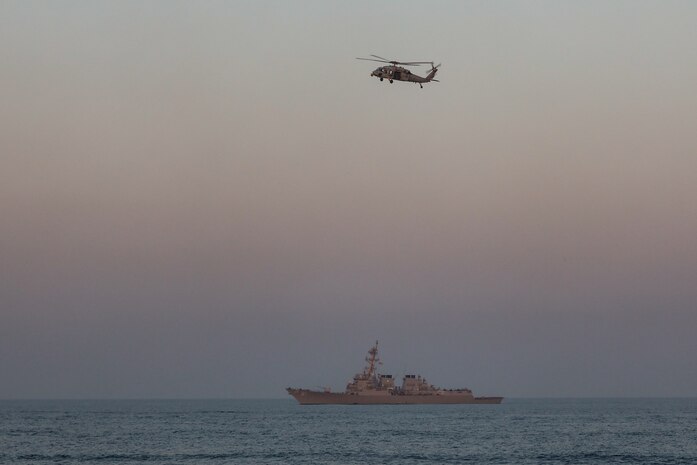 An MH-60R Seahawk helicopter flies over the guided-missile destroyer USS Winston S. Churchill (DDG 81) during the joint air operations in support of maritime surface warfare (AOMSW) exercise in the Arabian Gulf, Sept. 24. Combined integration operations between joint U.S. forces are regularly held to maintain interoperability and the capability to counter threats posed in the maritime domain, ensuring freedom of navigation and free flow of commerce throughout the region's heavily trafficked waterways. (U.S Army photo by Spc. William Gore)