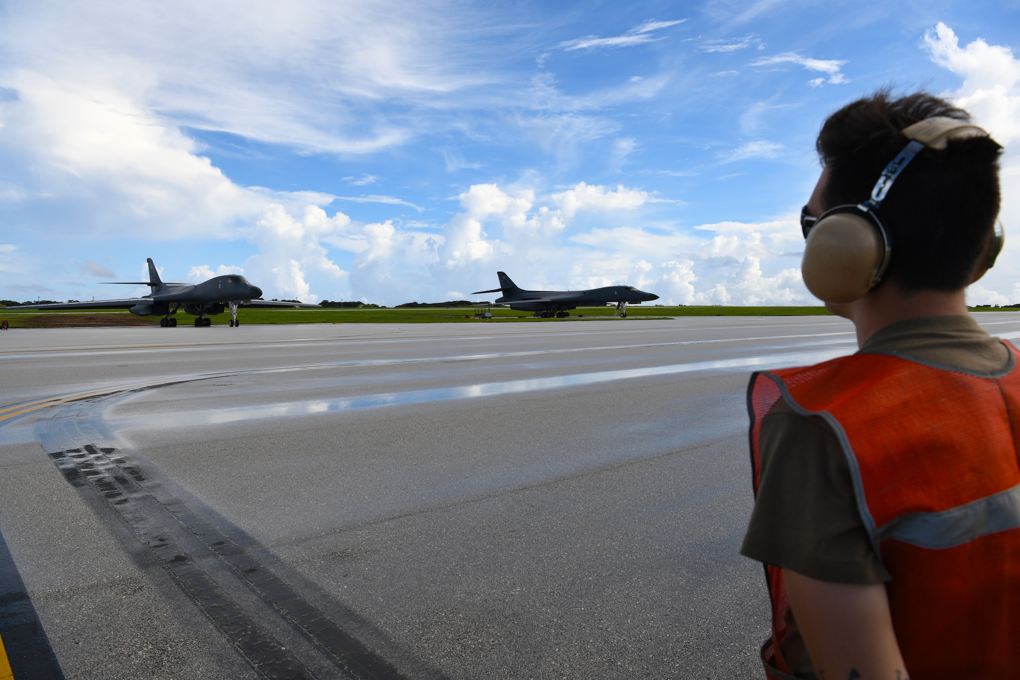 A maintainer assigned to the 34th Expeditionary Bomb Squadron, Ellsworth Air Force Base, S.D., prepares to marshal a B-1B Lancer for take-off during Exercise Valiant Shield at Andersen AFB, Guam, Sept. 18, 2020. Valiant Shield is a series of military exercises that promote integration and interoperability among joint forces. Each successive exercise builds on lessons learned from the previous training to validate and enhance complementary capabilities and develop new tactics, techniques and procedures. (U.S. Air Force photo by Staff Sgt. Nicolas Z. Erwin)