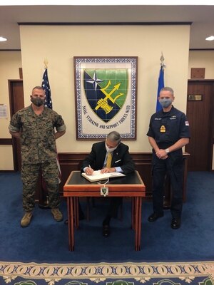 Acting Under Secretary of the Navy, the Honorable Gregory J. Slavonic, signs the visitor's book at Naval Striking and Support Forces NATO (STRIKFORNATO).