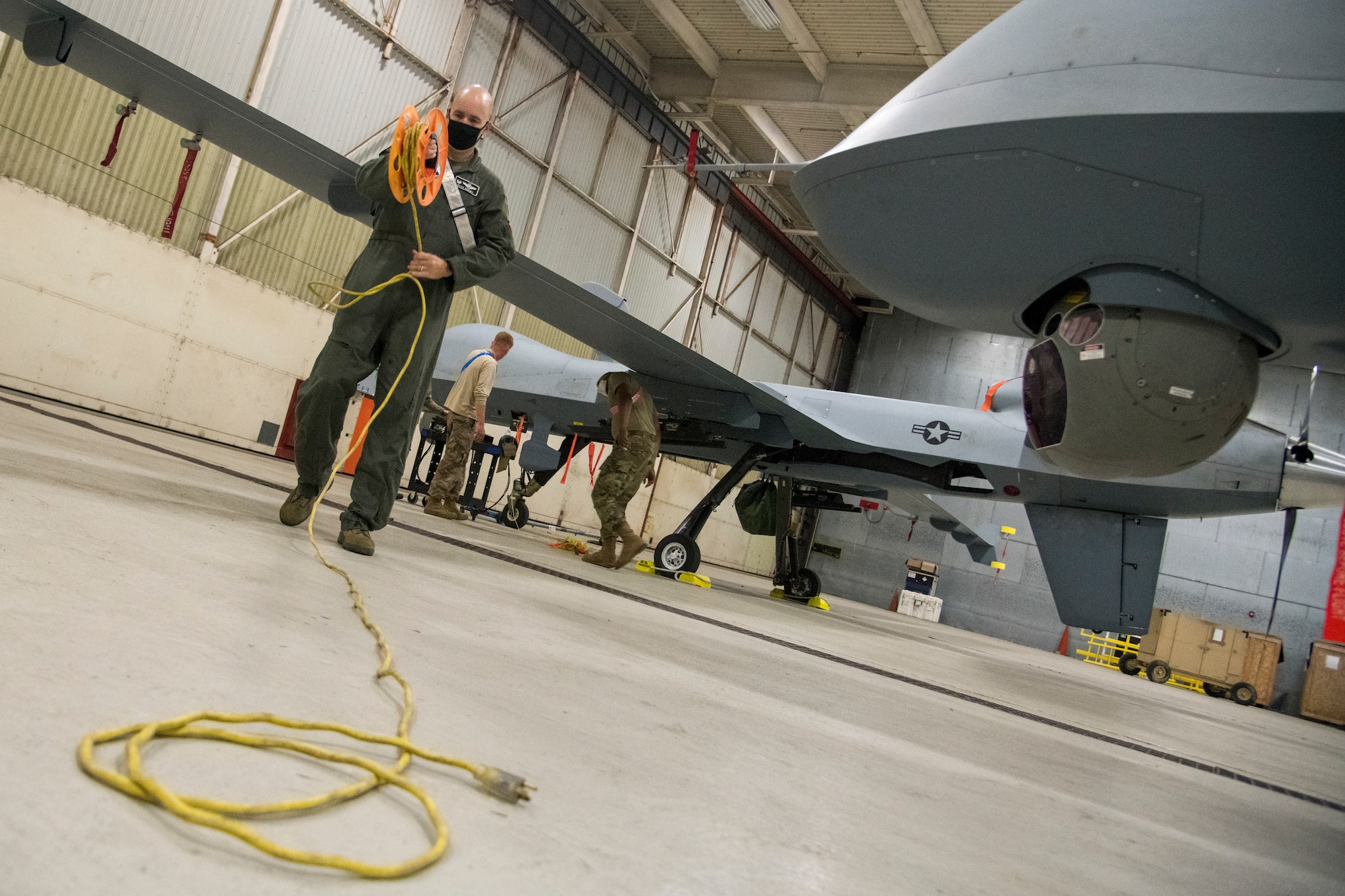 Col. Ryan Keeney, 49th Wing Commander, rolls up a power supply cable during Exercise Agile Reaper, Sept. 23, 2020, at Naval Air Station Point Mugu, California. Keeney supported exercise participants during his visit by aiding in recovering aircraft, chalking the plane and assisting in maintenance duties. (U.S. Air Force photo by Senior Airman Collette Brooks)