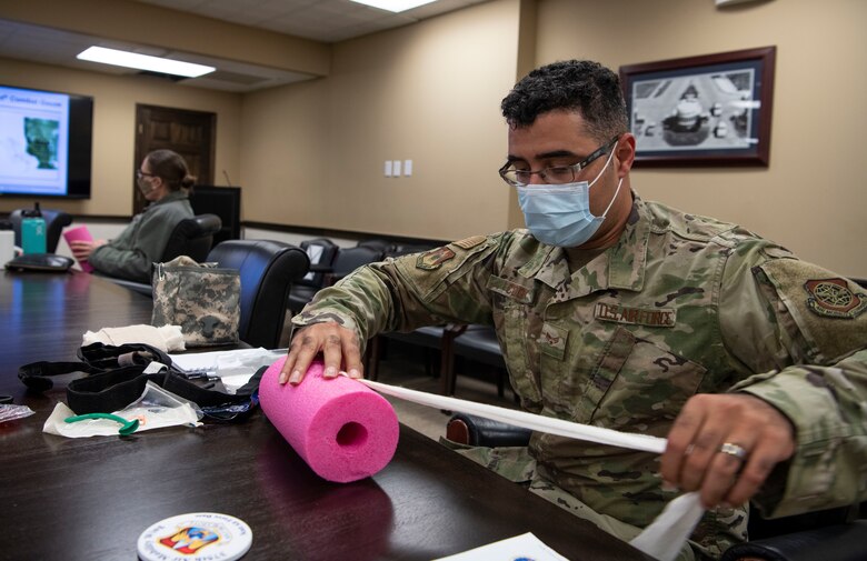 Airman stuffs a fake wound with gauze.