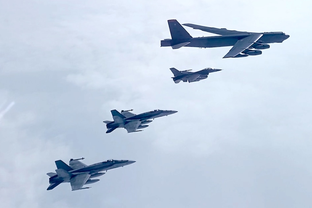 Four military aircraft fly in formation.