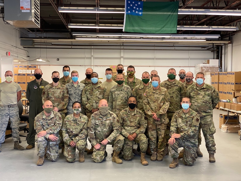 Service members wearing face masks pose for a photo.