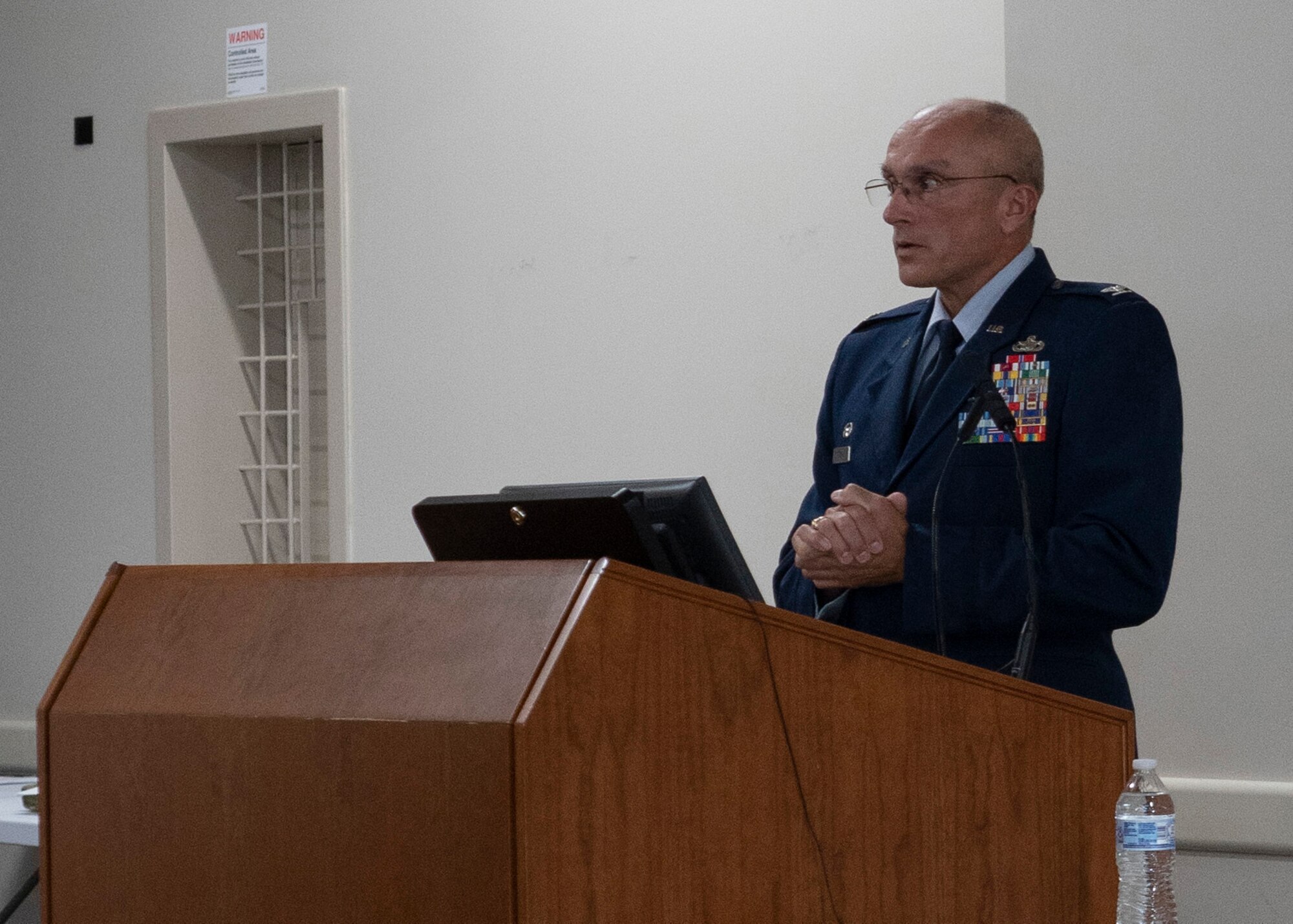 Photo of Airman standing behind podium