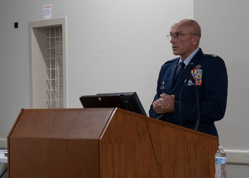 Photo of Airman standing behind podium
