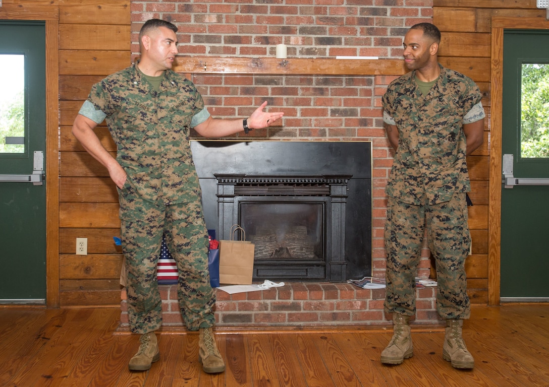 U.S. Marine Corps Lt. Col. Julian Flores, left, commanding officer of Headquarters and Headquarters Squadron (H&HS), congratulates Sgt. Donatien Lake III, right, an aviation operation specialist with H&HS, for receiving the Service Person of the Quarter award at the Hancock Lodge, Marine Corps Air Station Cherry Point, North Carolina, July 28, 2020