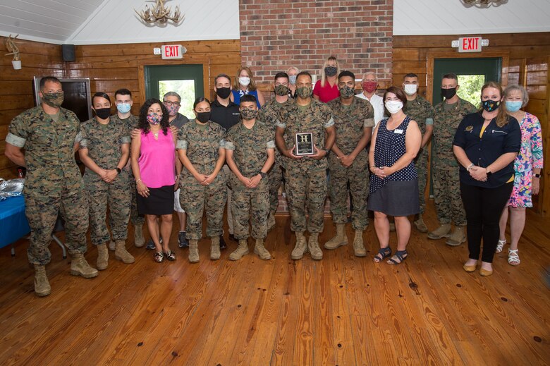 U.S. Marine Corps Sgt. Donatien Lake III, center, an aviation operation specialist with Headquarters and Headquarters Squadron, the recipient of the Service Person of the Quarter award, poses with the Marines and civilians who attended the ceremony at the at Hancock Lodge, Marine Corps Air Station (MCAS) Cherry Point, North Carolina, July 28, 2020