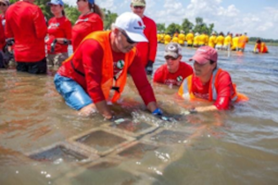 Beck at work on oyster reef restoration in Mobile Bay, Alabama, with colleagues from The Nature Conservancy©.