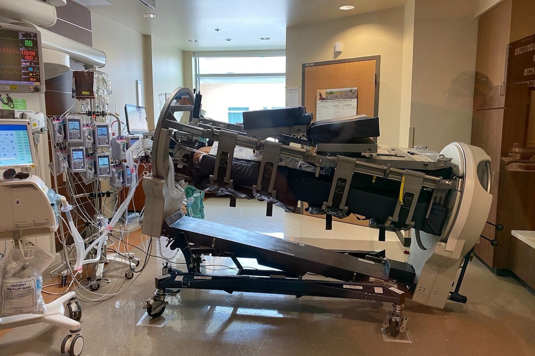 A specially equipped hospital bed is in a room with many monitors and other medical equipment.