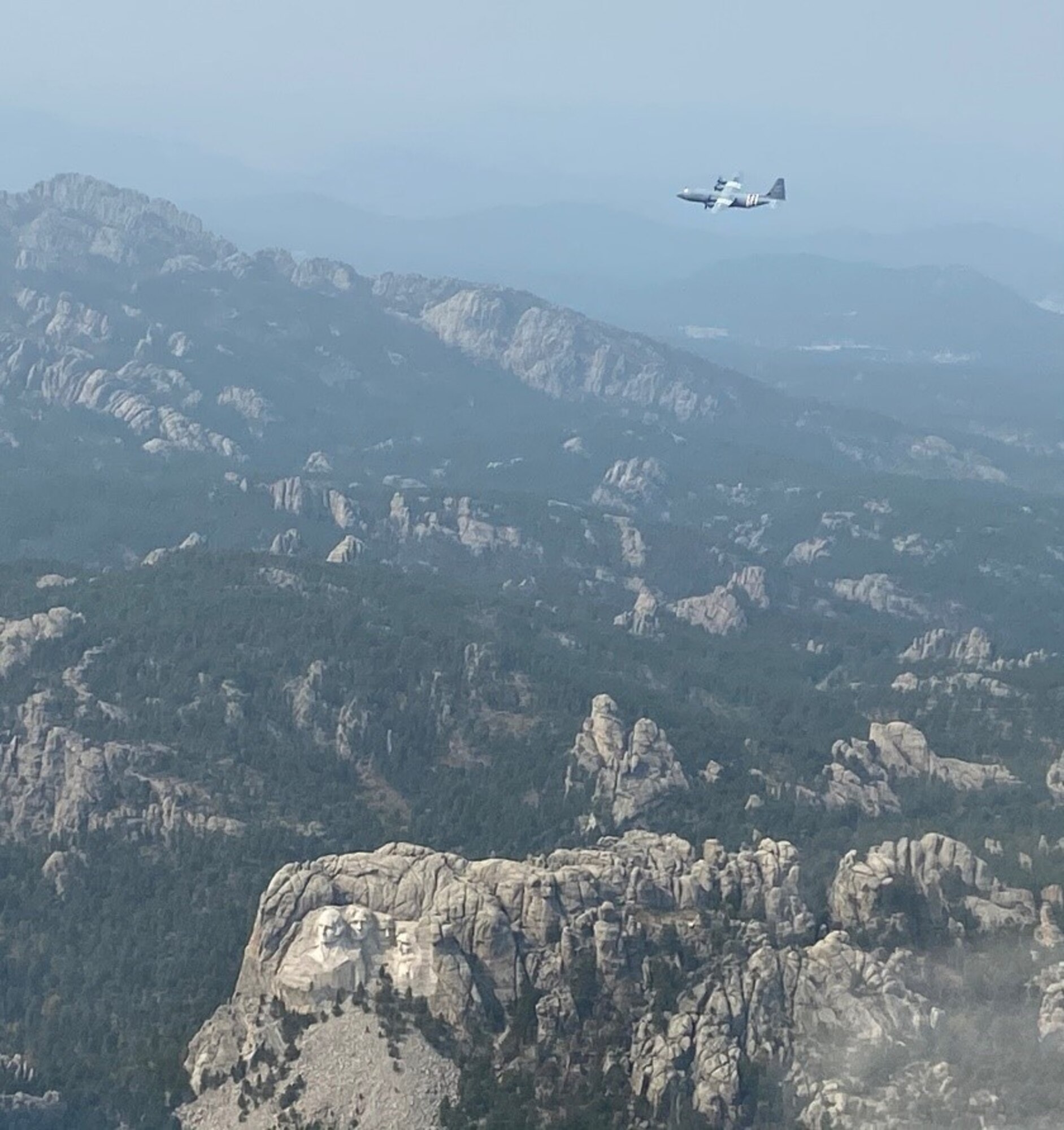 An aircraft flies through the mountains