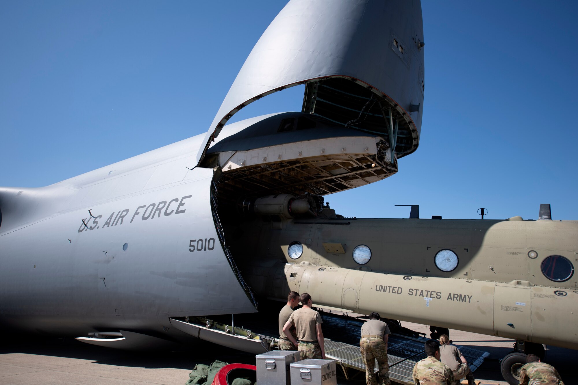 U.S. Airmen and Soldiers train together to load a Chinook-47 helicopter in a C-5M Super Galaxy.