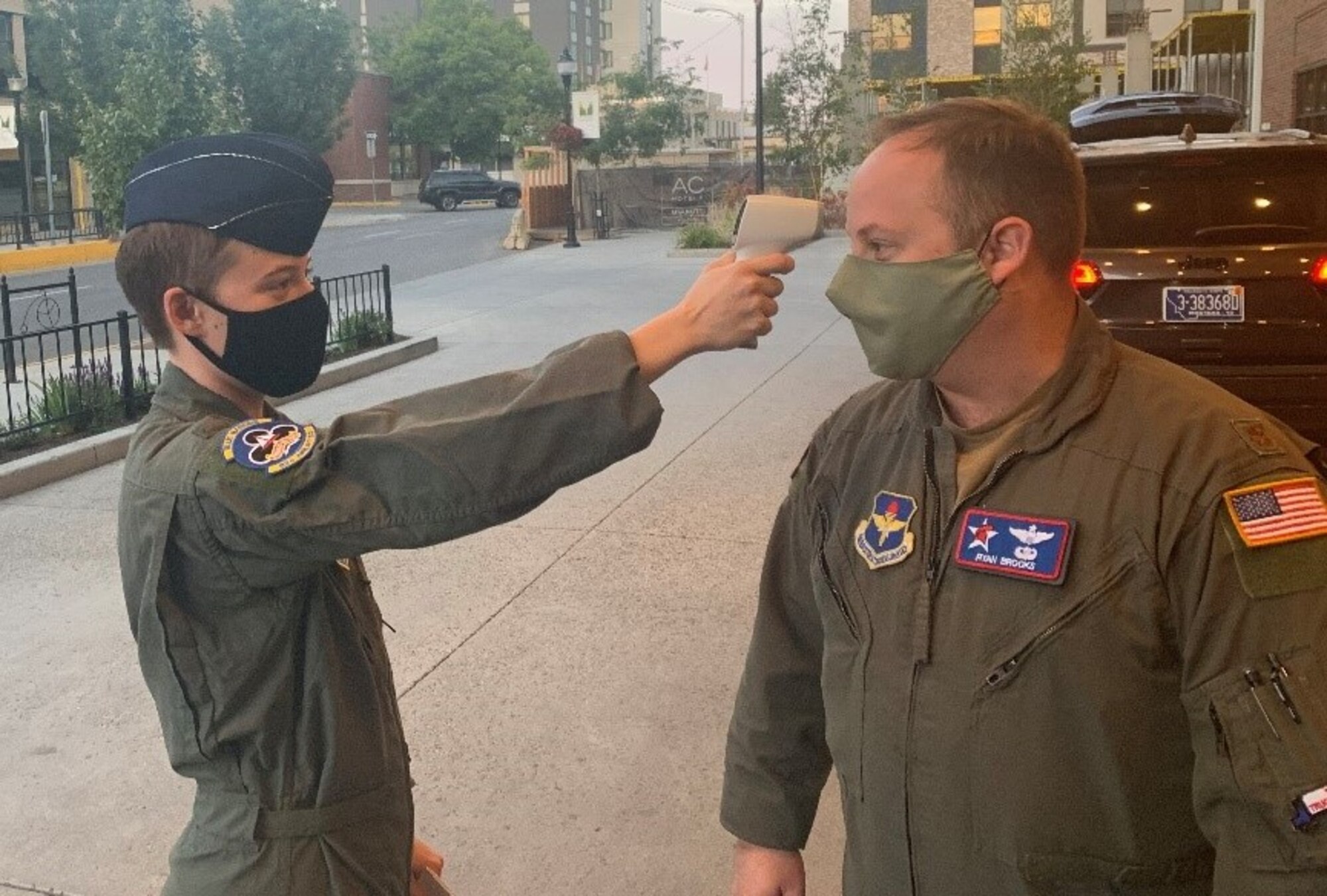 A person checks another person's temperature