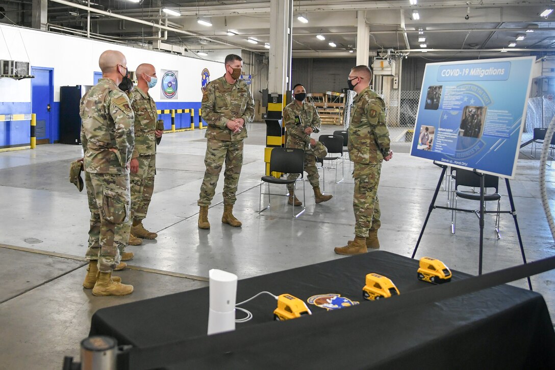 2nd Lt. Casey Lockett (far right), 75th Logistics Readiness Squadron, makes a presentation to Lt. Gen. Gene Kirkland, Air Force Sustainment Center commander, and Chief Master Sgt. David Flosi, AFSC command chief master sergeant.
