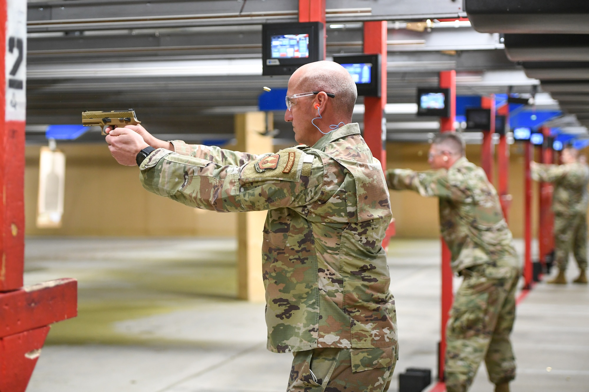 Chief Master Sgt. David Flosi, Air Force Sustainment Center command chief master sergeant, shoots the M18 pistol.