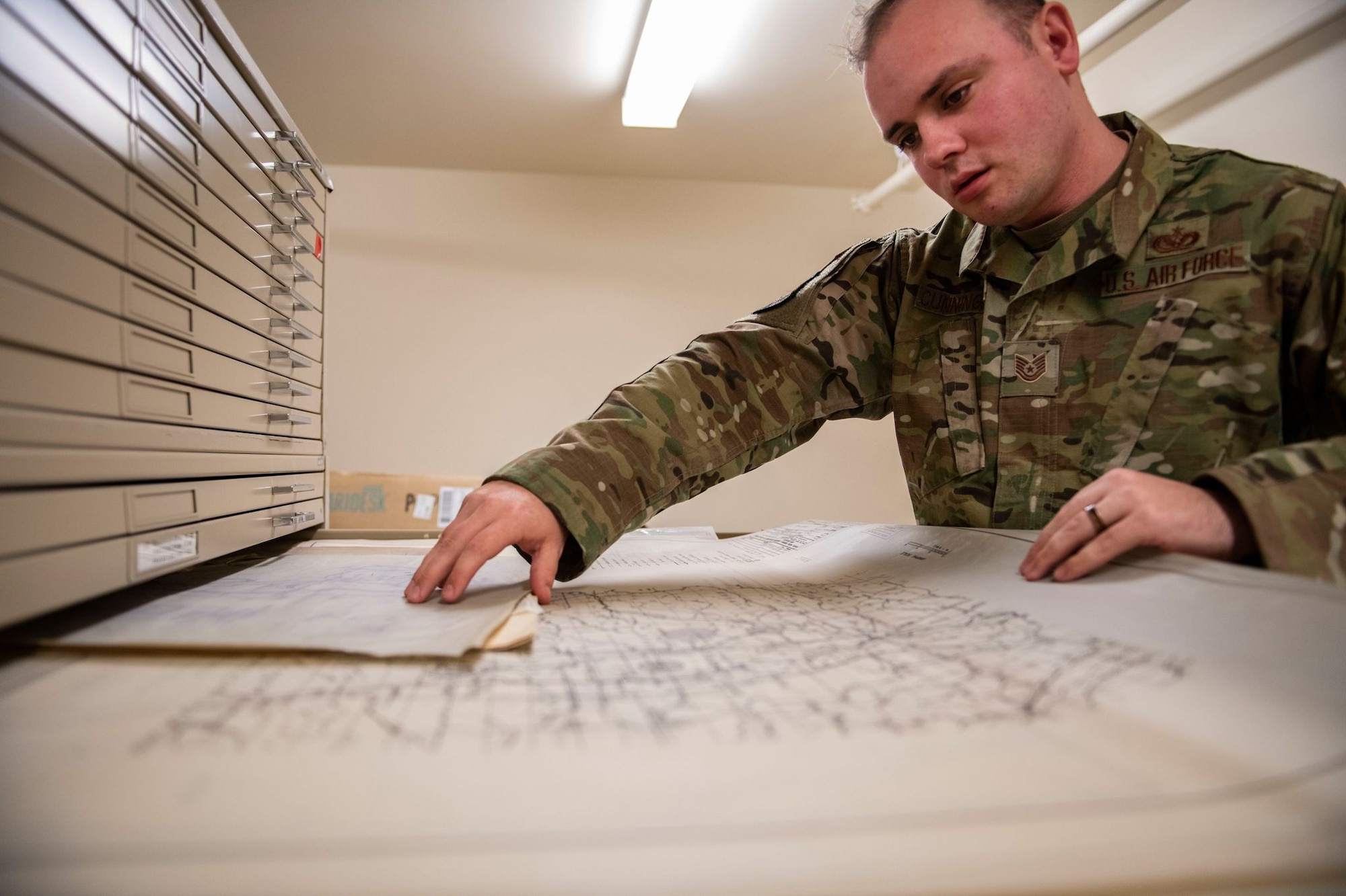 Tech. Sgt. Kevin Cuningham, 9th Civil Engineer Squadron noncommissioned officer in charge of Execution Support, pulls a map out of a cabinet on Beale Air Force Base.