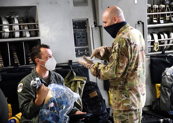 Airmen of the 932nd Airlift Wing's Aeromedical Evacuation Squadron (AES) prepare equipment for a training flight on a visiting C-17 aircraft September 26, 2020, Scott Air Force Base, Ill. At right, Air Force reservist Senior Master Sgt. Michael Mikoff goes over preflight equipment checklists with Senior Airman Adam Heyden, medical technician. 932nd Airlift Wing members worked improving and refining hands on skills at the Illinois reserve unit, which included cross-training with members of the 131st Medical Group from Missouri, and the 445th Airlift Wing from Ohio. Airmen worked together on first aid skills and patient care in the air.  The intense two day training was designed to help Airmen be ready for any future medical missions. (U.S. Air Force photo by Lt. Col. Stan Paregien)