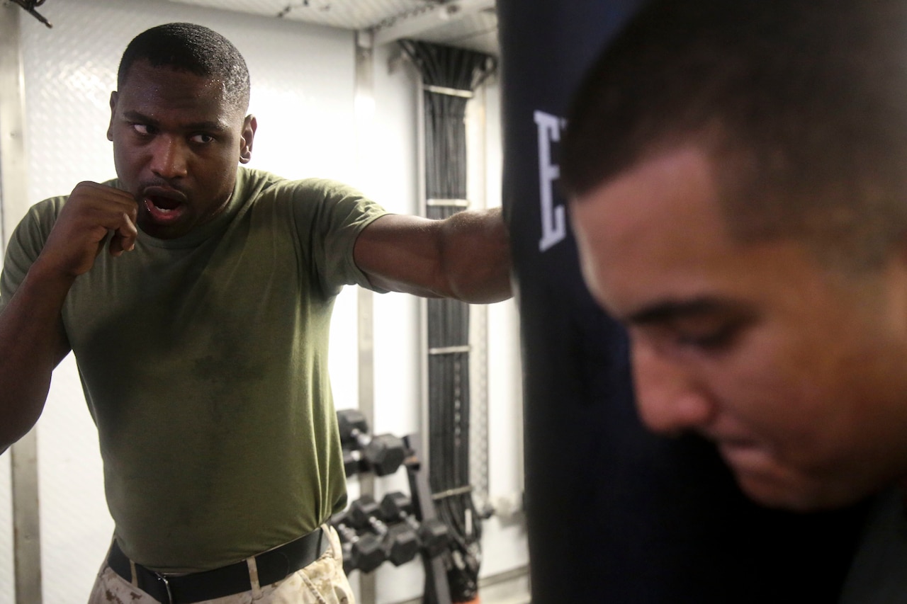 A Marine hits a punching bag.