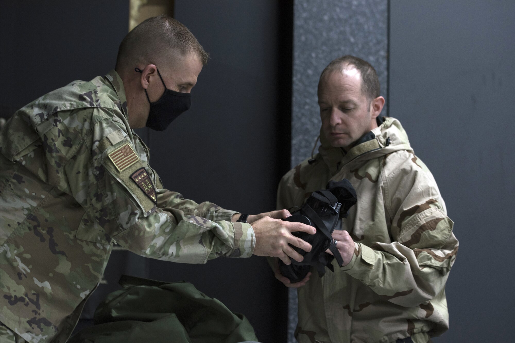 U.S. Air Force Chief Master Sgt. Jason Selman, United States Air Force in Europe-Air Forces Africa Chemical, Biological, Radiological, and Nuclear functional manager, left, and Lt. Col. Boris Shif, chief Intelligence, Surveillance, and Reconnaissance security cooperation division, right, inspect a gas mask together on Ramstein Air Base, Germany, Sept. 24, 2020.