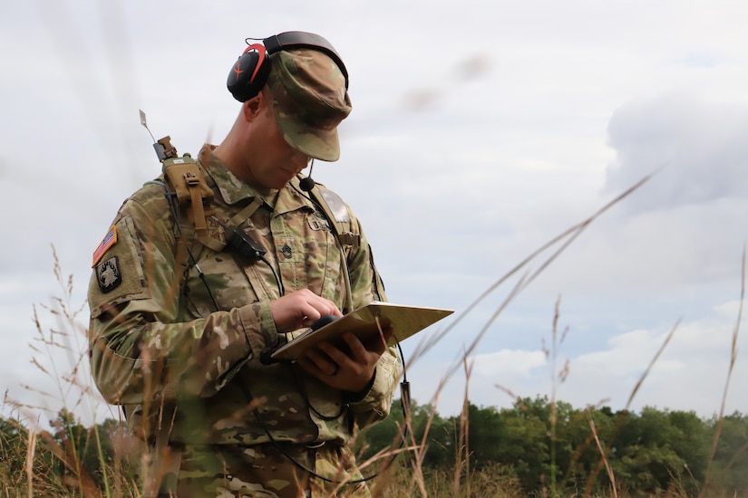 A soldier uses network gear in the field.