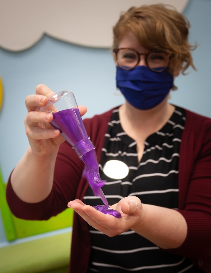 Sarah Newton, the Marine Corps Community Services youth services and programming manager, shows off a bottle of slime at the Marine Warrior Library on Marine Corps Air Station Cherry Point, North Carolina, July 15, 2020. The bottle of slime is one of the more popular Summer Reading Program prizes offered. With COVID-19 effecting normal indoor summer activities, the library now offers the reading program virtually.  (U.S. Marine Corps photo by Cpl. Alexandra Santos Arambulo)