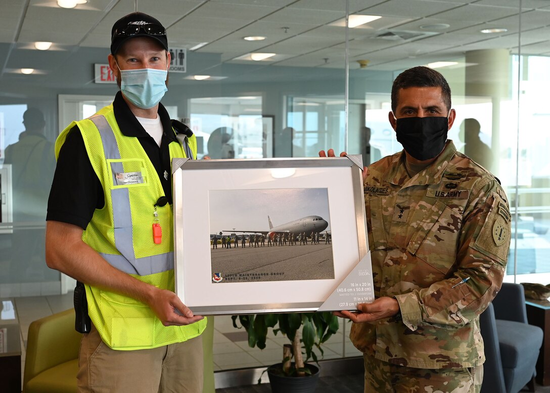 NH Adjutant Gen. David Mikolaities presents Tim Chrzaszcz, operations supervisor with Signature Airlines, with a framed picture of a KC-46 and Pease airmen during a tour on Sept. 16 at Manchester-Boston Regional Airport. The company has helped faciliate Guard operations at the airport while the runway at Pease is resurfaced. Photo by Staff Sgt. Charles Johnston, deputy state PAO.