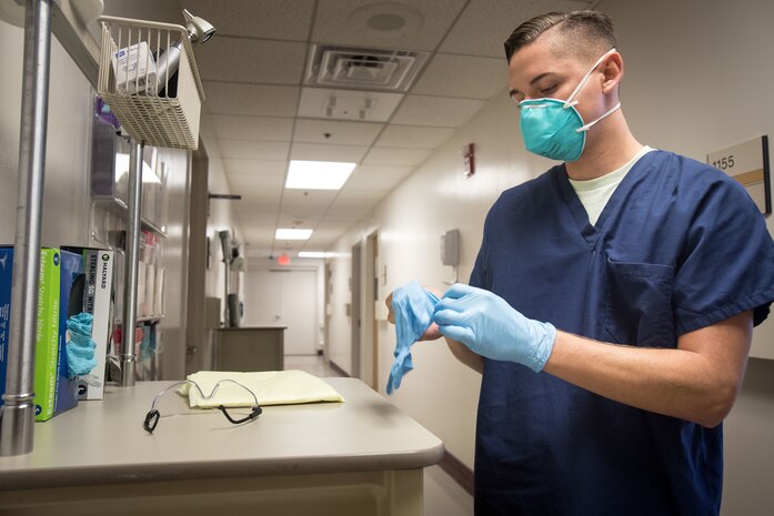 A U.S. Navy Hospitalman puts on personal protective equipment before seeing a possible Coronavirus patient at the respiratory triage clinic, Marine Corps Air Station Cherry Point, N.C., Aug. 6.