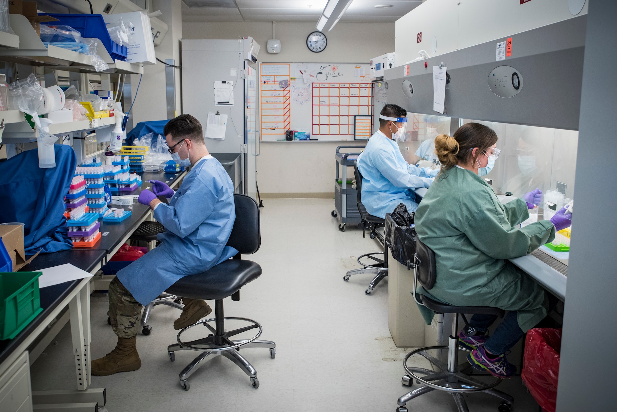 Medical laboratory technicians (left) Staff Sgt.Taylor Wiens and (front right) Dannielle Parlett with Tech. Sgt. Kevin Blevins (back right), NCOIC, Microbiology, from the United States Air Force School of Aerospace Medicine’s Epidemiology Laboratory are separating a larger sample into smaller parts for COVID-19 testing. The Epi Lab is the sole clinical reference lab in the Air Force, and USAFSAM is part of AFRL’s 711th Human Performance Wing headquartered at Wright-Patterson Air Force Base in Dayton, Ohio.  (U.S. Air Force photo by Richard Eldridge)