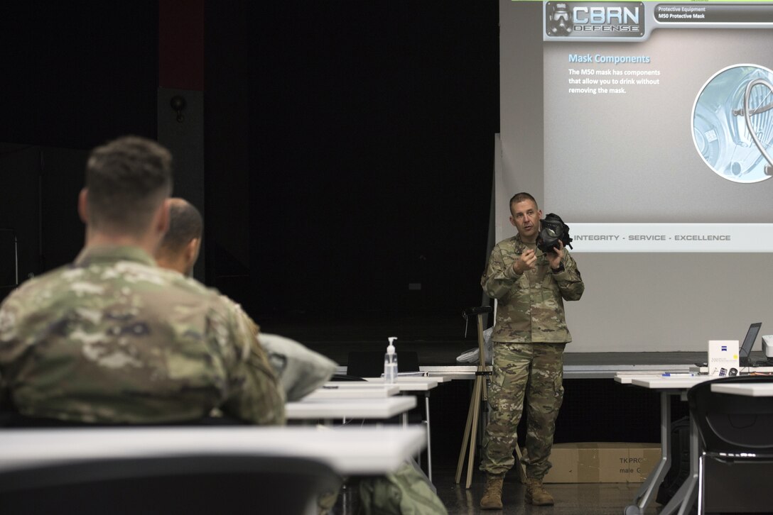 U.S. Air Force Chief Master Sgt. Jason Selman, United States Air Force in Europe-Air Forces Africa Chemical, Biological, Radiological, and Nuclear functional manager, demonstrates how to detach the drinking tube on a gas mask during a CBRN defense course on Ramstein Air Base, Germany, Sept. 24, 2020.