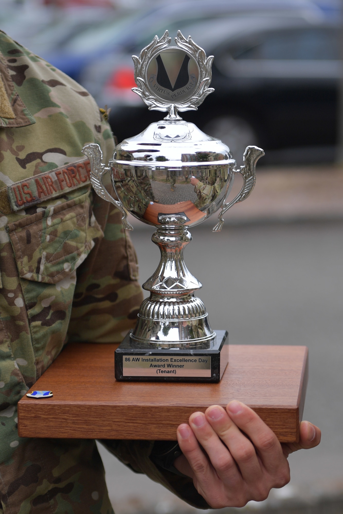 A close-up of an Airman holding a trophy.