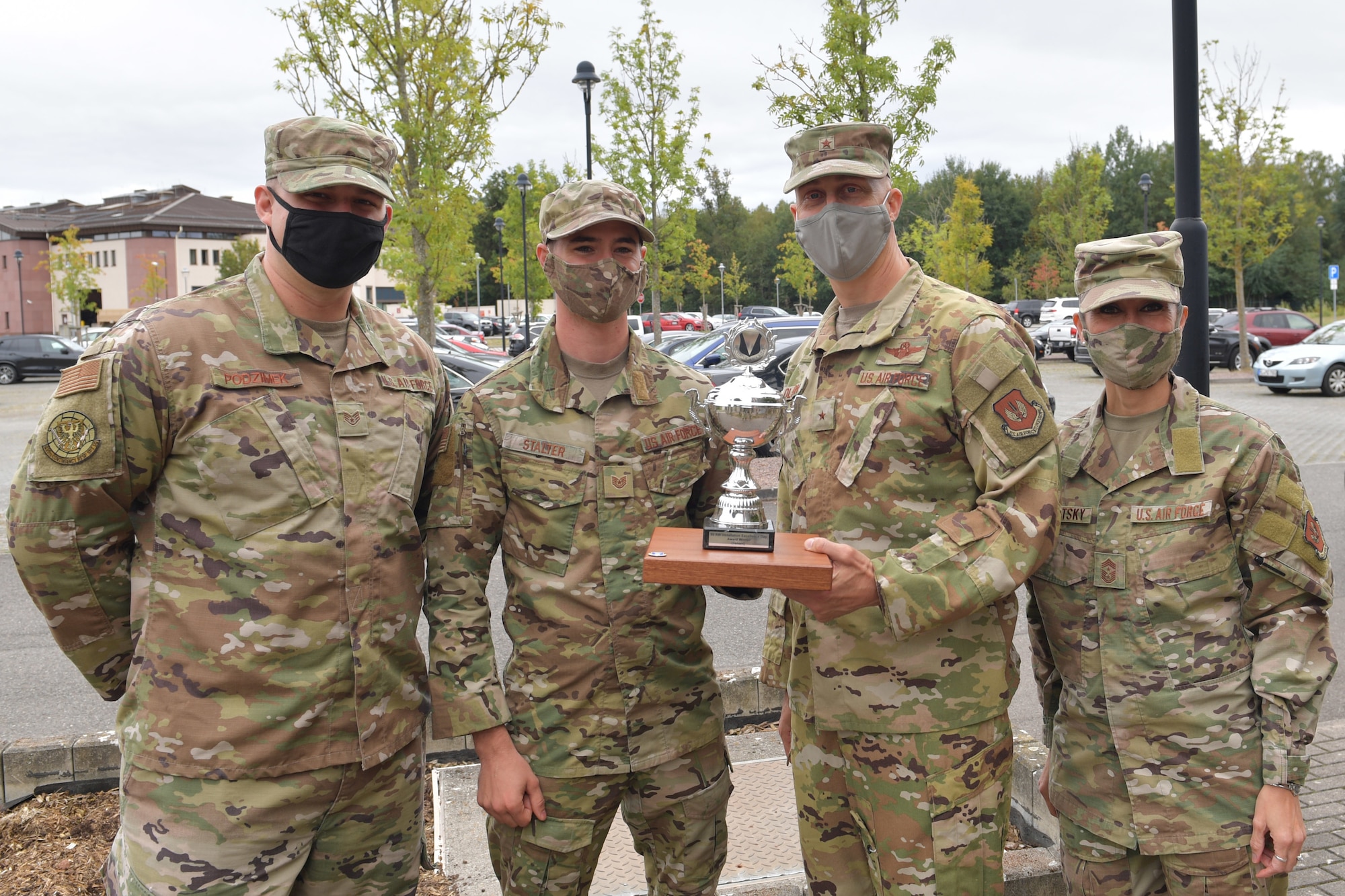 Four Airmen standing with a trophy.