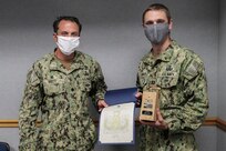 Expeditionary Exploitation Unit One (EXU-1) Commanding Officer Cmdr. Edgar Britt presents the Rear Admiral Draper L. Kauffman Leadership Award to Lt. Thomas Cowhey, Sept. 29. Named after the father of EOD, this annual award is presented to an EOD officer who serves in a platoon or company commander position. (U.S. Navy photo by Matthew Poynor)