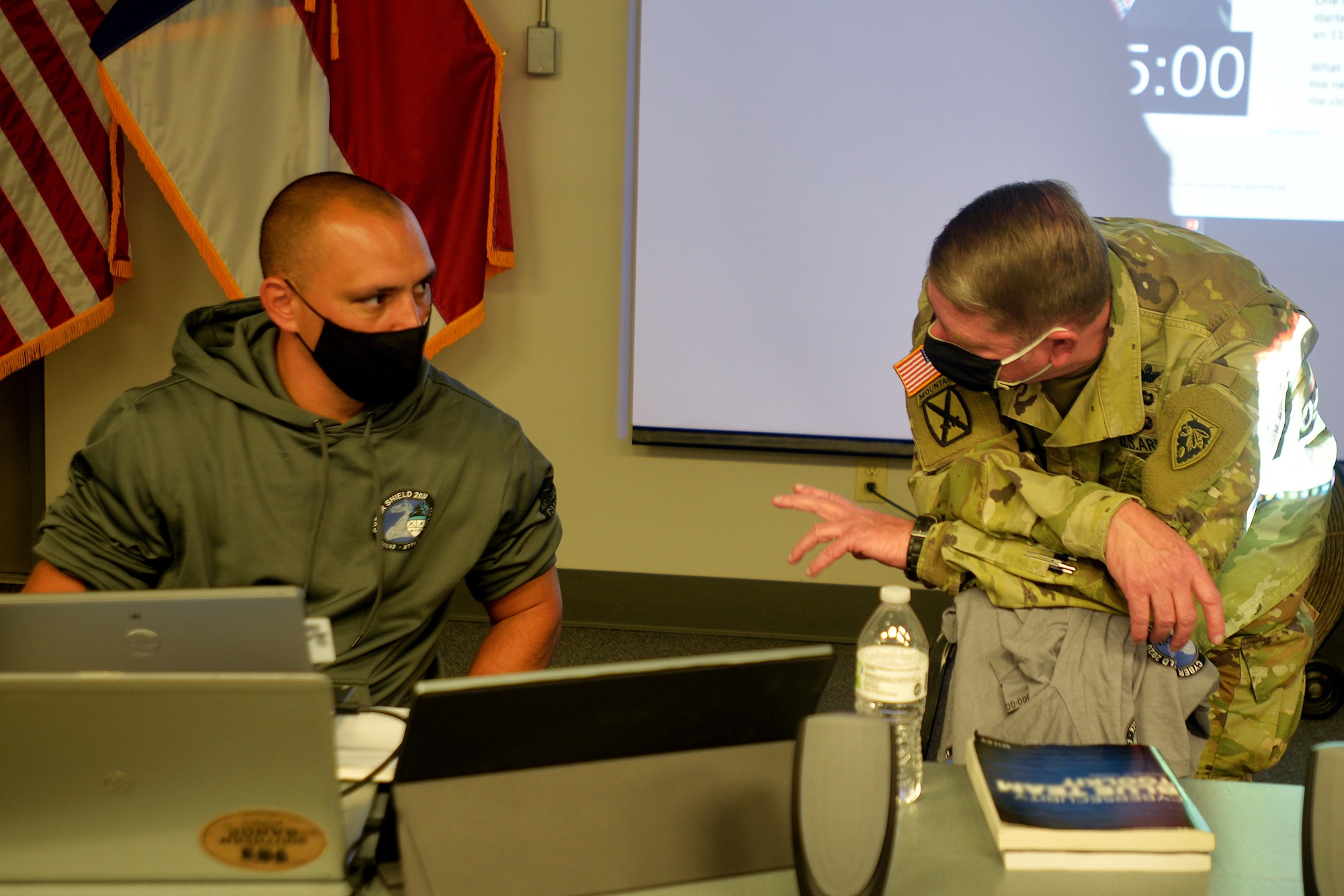 North Carolina Army National Guard Robbie Felicio, North Carolina National Guard (NCNG) Chief Information Officer, left, and NCNG Adjutant General Maj. Gen. Maj. Gen. Todd Hunt discuss cyber operations during Cyber Shield 2020 held at the NCNG’s Fort Fisher Training Center, Kure Beach, North Carolina, Sept. 24, 2020.  Cyber Shield 2020 is a virtual national exercise where NCNG participants join their National Guard peers across the country, testing their response to real world cyber threats to government and private industry networks and information technology infrastructure. (U.S. Army National Guard photo by Robert Jordan, North Carolina National Guard Public Affairs)