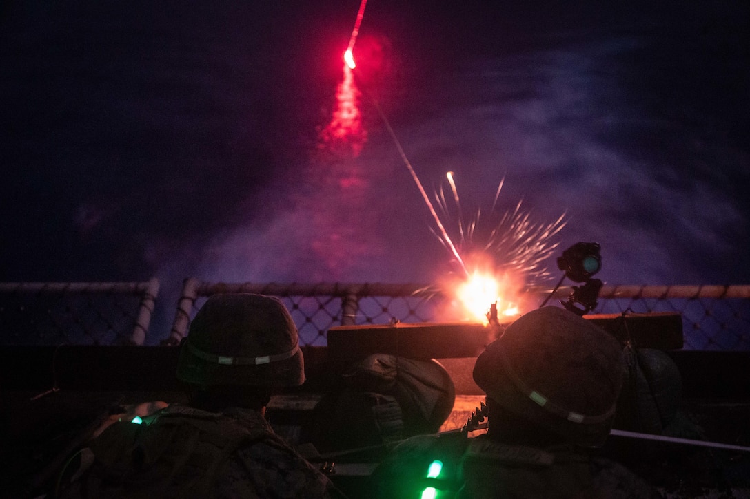 U.S. Marines fire an M240B medium machine gun during a night shoot aboard dock landing ship USS Germantown (LSD 42), Sept. 27.