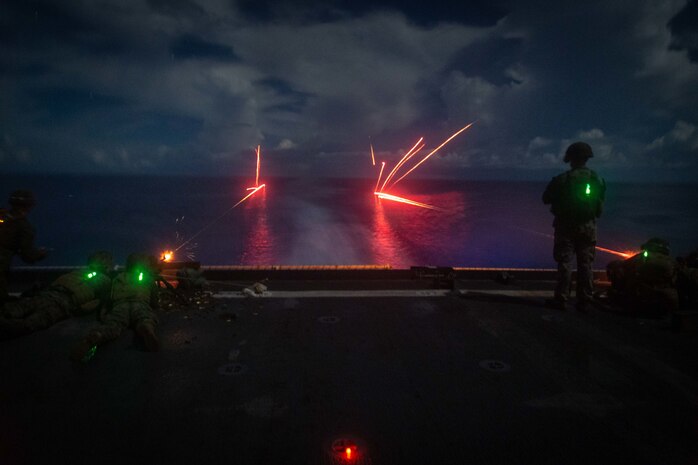 U.S. Marines fire an M240B medium machine gun during a night shoot aboard dock landing ship USS Germantown (LSD 42), Sept. 27.