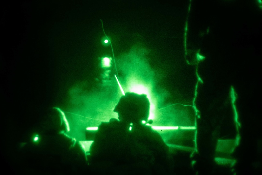 U.S. Marines fire an M240B medium machine gun during a night shoot aboard dock landing ship USS Germantown (LSD 42), Sept. 27.