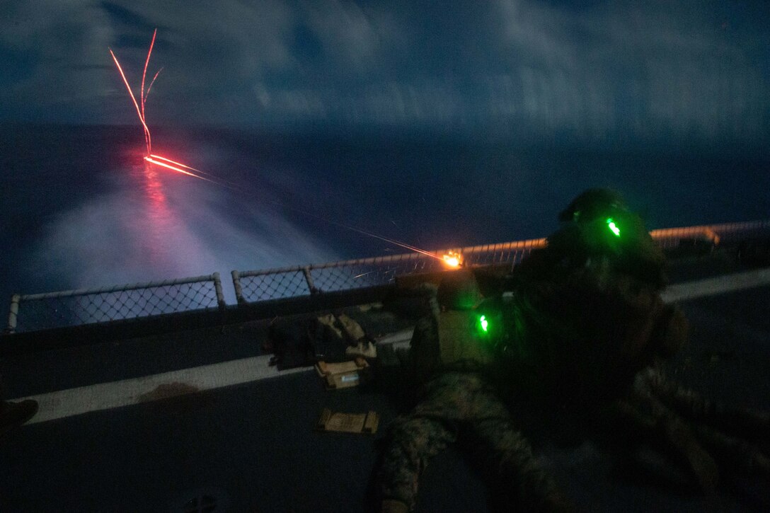U.S. Marines fire an M240B medium machine gun during a night shoot aboard dock landing ship USS Germantown (LSD 42), Sept. 27.