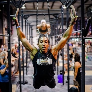 woman swings from gymnastic rings.