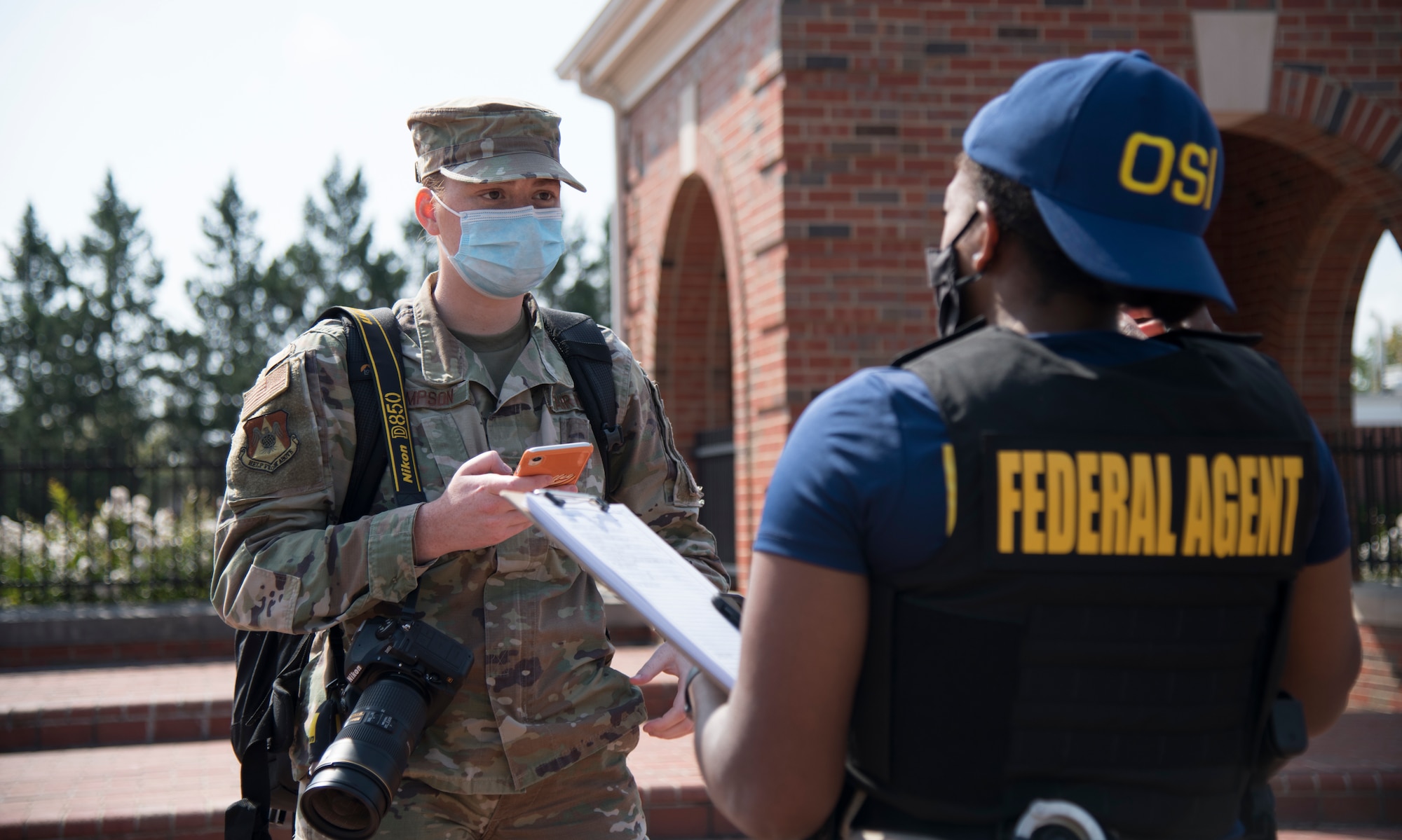 U.S. Air Force photojournalist speaks with officer