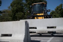 Heavy equipment moves concrete barrier