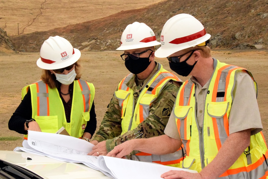 USACE Sacramento District Commander COL James Handura (center) and other project leaders go over construction plans as groundbreaking gets underway on the Tule River Spillway Enlargement Project at Success Lake near Porterville, California.