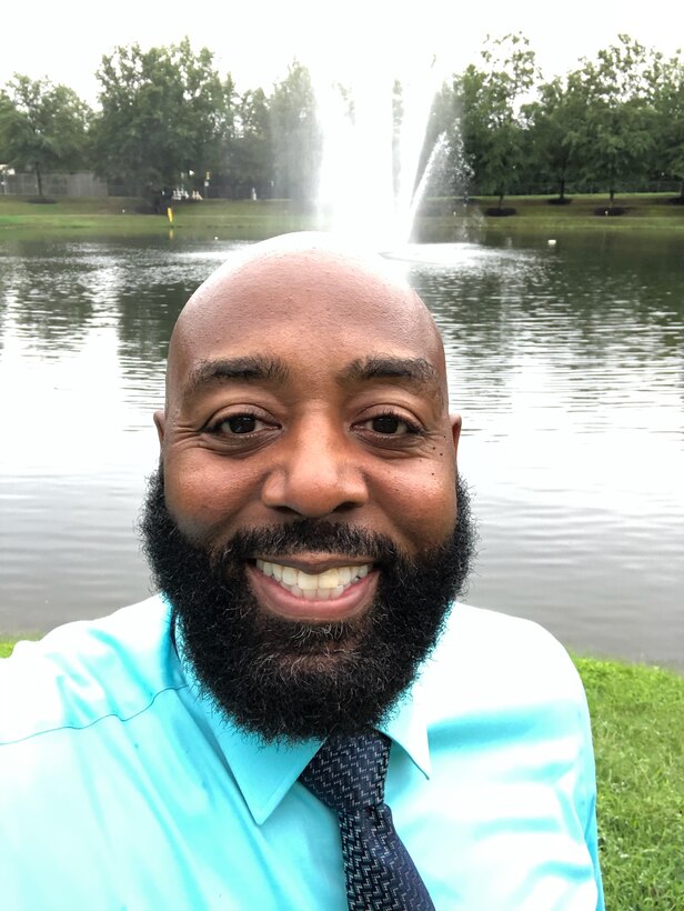 Man taking selfie at DLA HQ with pond in background.