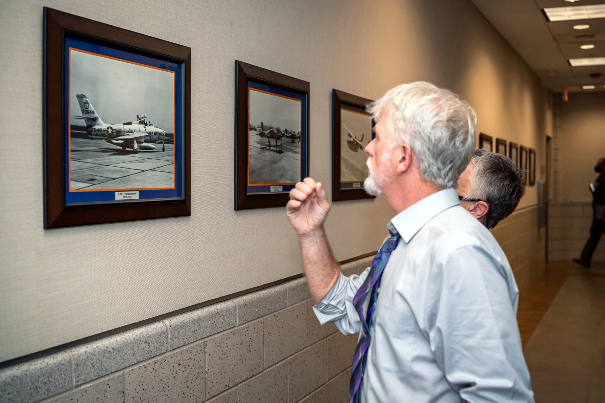 Man and woman looking at aircraft photo.