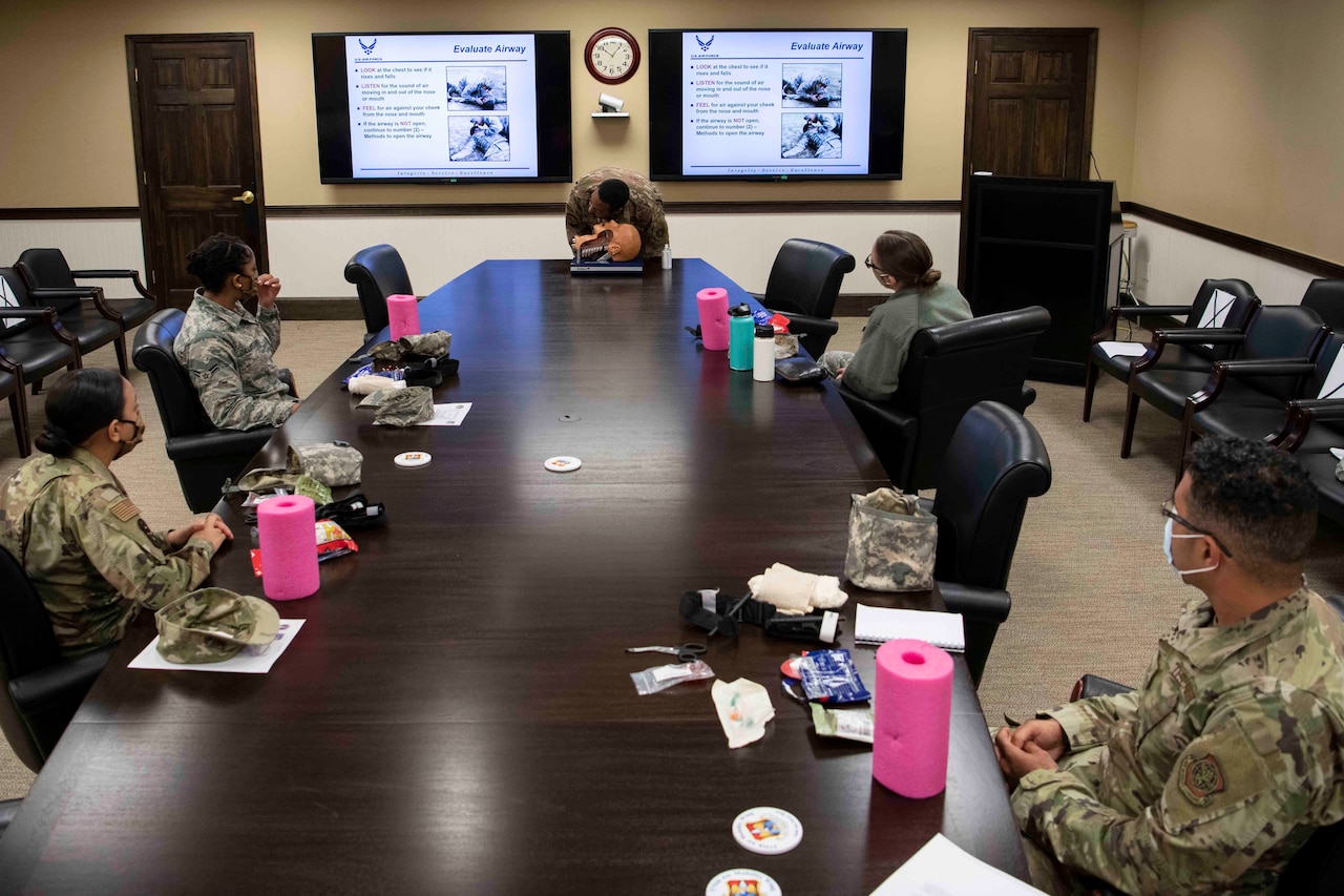 Airmen wearing face masks receive emergency medical training.