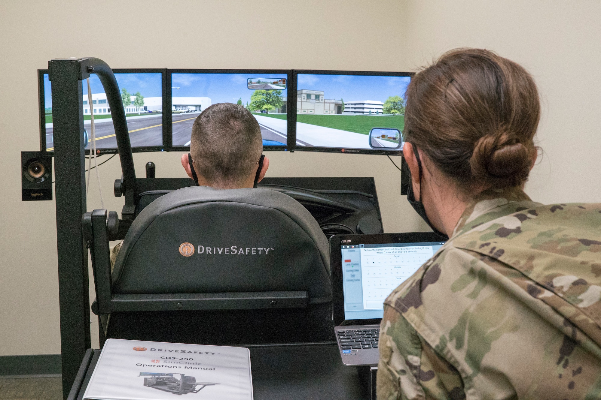U.S. Air Force Major Elizabeth Trehan, 673d Medical Operations Squadron traumatic brain injury clinic director, demonstrates the capabilities of a driving simulator tool used for TBI treatment to U.S. Air Force Chief Master Sgt. Lee P. Mills, 673d Air Base Wing and Joint Base Elmendorf-Richardson command chief, during a 673d MDOS immersion tour at JBER, Alaska, Sept. 24, 2020. Aguilar familiarized herself with the 673d MDOS and its role in supporting installation readiness after taking command of the installation on July 14, 2020. The 673d MDOS works to enhance the performance and overall health of JBER in order to ensure combat effectiveness. (U.S. Air Force photo by Senior Airman Crystal A. Jenkins)