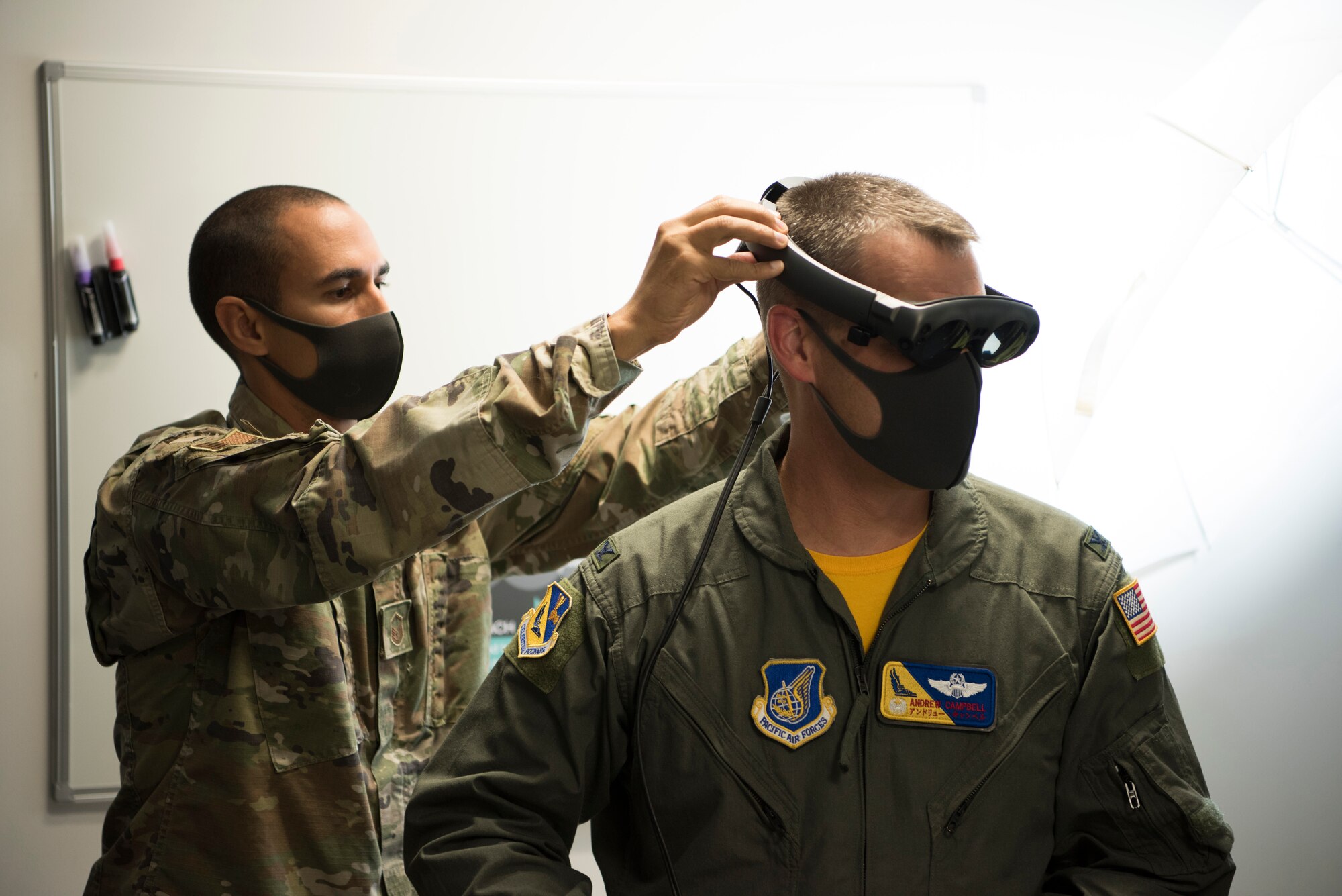 Master Sgt. Kenneth Martin, 753rd Special Operations Aircraft Maintenance Squadron production superintendent puts augmented reality goggles on Col. Andrew Campbell, 374th Airlift Wing commander, in the newly-opened innovation lab at Yokota Air Base, Japan, Sept. 25, 2020. Although newly created and opened, 'The Dojo' is stocked with top-tier technology such as AR, 3D printers, prototyping software, and reverse-engineering tools. (U.S. Air Force photo by Staff Sgt. Taylor A. Workman)