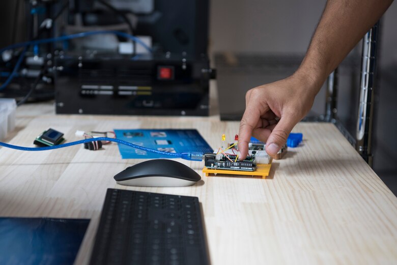 Master Sgt. Kenneth Martin, 753rd Special Operations Aircraft Maintenance Squadron production superintendent, reaches for an Arduino in the the Dojo, a newly-opened innovation lab at Yokota Air Base, Japan, Sept. 25, 2020. An Arduino allows users to prototype or create electronic systems and is just one of the many tools available in the innovation lab. (U.S. Air Force photo by Staff Sgt. Taylor A. Workman)