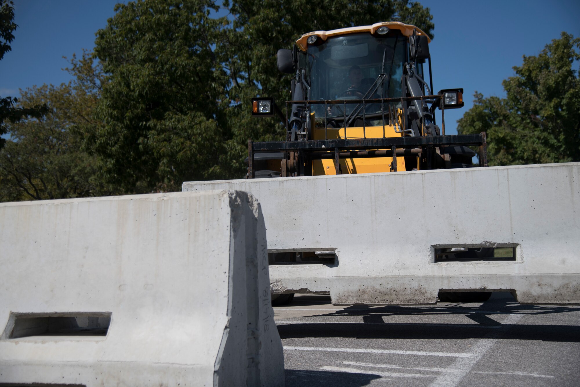 Heavy equipment moves concrete barrier
