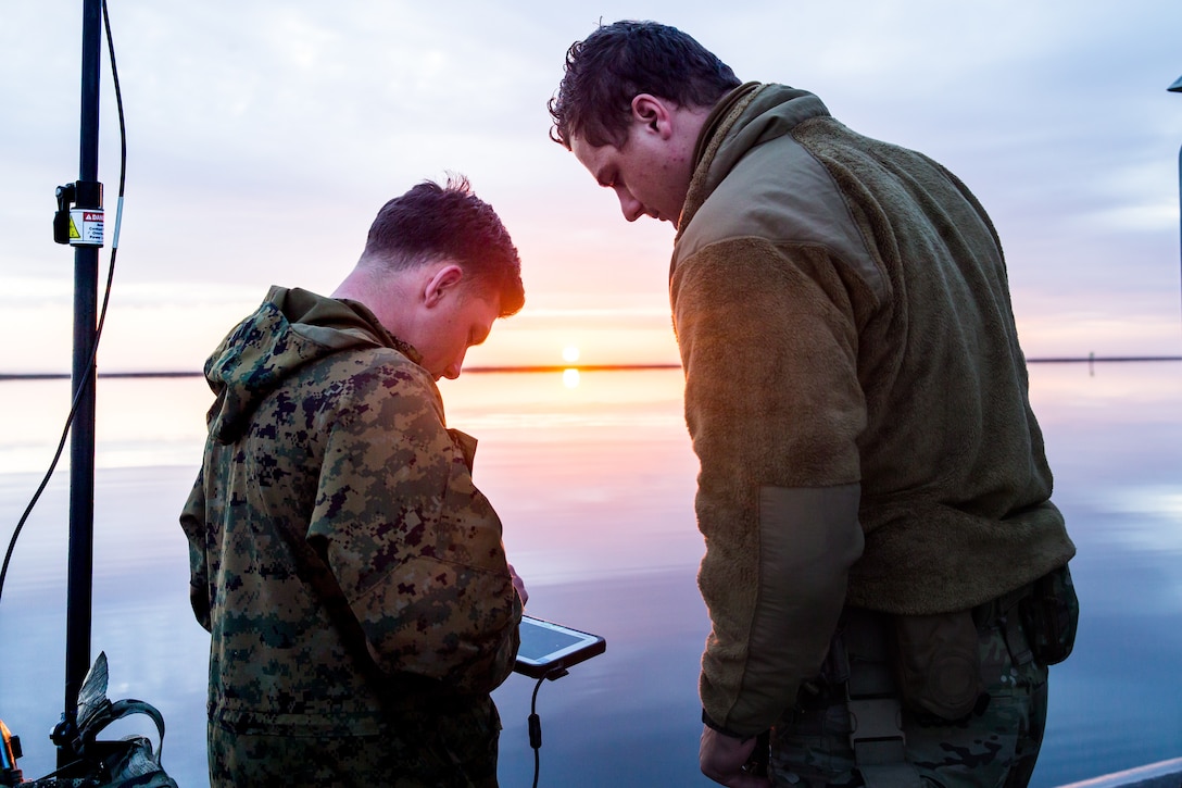 U.S. Marine Corps Sgt. Jeramiah Meade, Left, a section chief with 2nd Radio Battalion, 2d Marine Division, teaches U.S. Coast Guard Petty Officer 3rd Class Zachery Ribbons, Right, a North Benton, O.H., native and machinery crewman with Maritime Security Response Team East, how to use a electronic warfare system during a joint-service training exercise on Marine Corps Air Station Cherry Point, N.C., March 26, 2021. The purpose of the week-long training was to increase interoperability with the U.S. Coast Guard and provide 2d Marine Division reconnaissance battalions with the opportunity to become familiarized with quick reaction and counter electronic warfare concepts. (U.S. Marine Corps photo by Cpl. Elijah Abernathy)