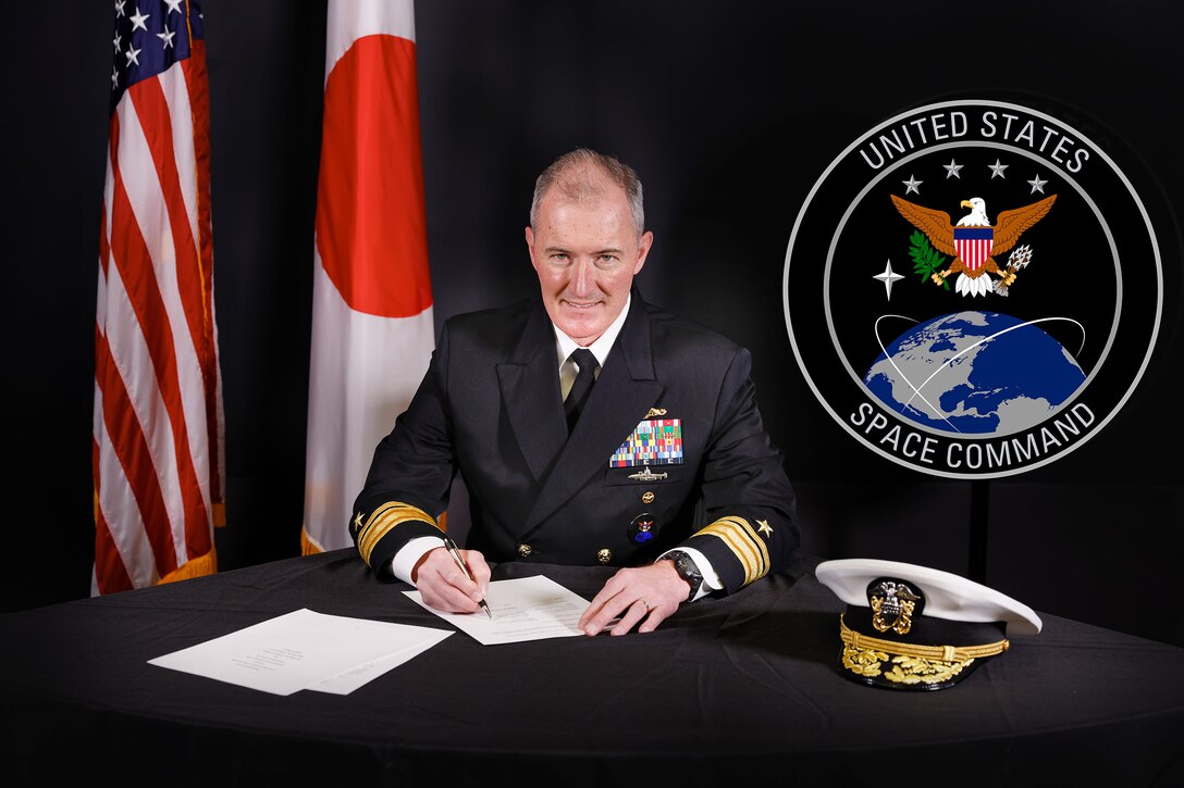 U.S. Navy admiral signs a memorandum of understanding.