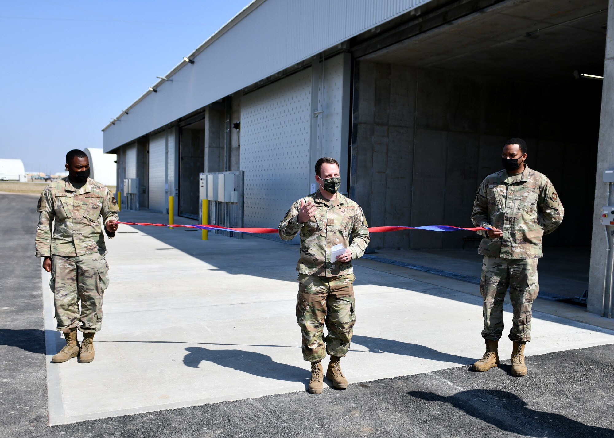 Senior Master Sgt. Roy Foster, 31st Munitions Squadron systems flight chief, center, speaks to guests at a ribbon cutting ceremony at Aviano Air Base, Italy, March 31, 2021. The ceremony marked the unveiling of three new earth-covered munitions storage modules on Area F. (U.S. Air Force photo by Staff Sgt. K. Tucker Owen)
